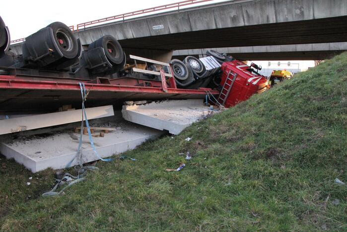 Vrachtwagen met betonplaten belandt op de kop