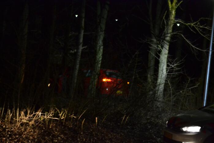 Auto vliegt uit de bocht en belandt tussen de bomen