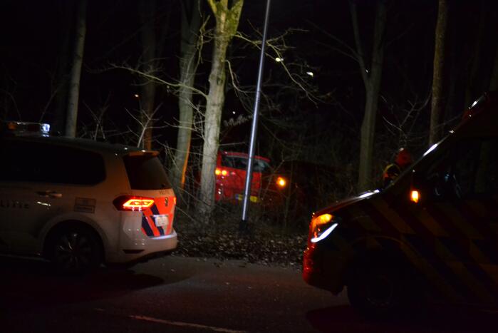 Auto vliegt uit de bocht en belandt tussen de bomen