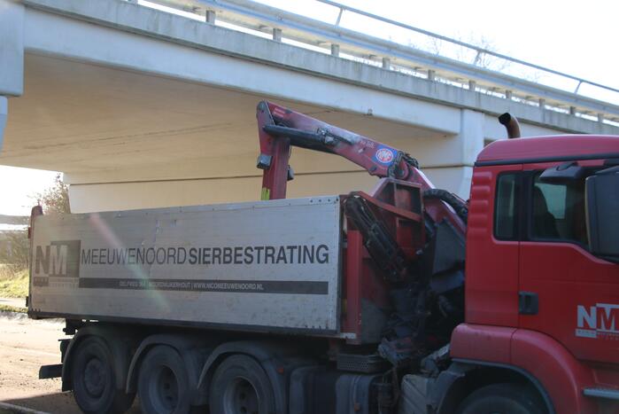 Vrachtwagen met kraan botst tegen viaduct