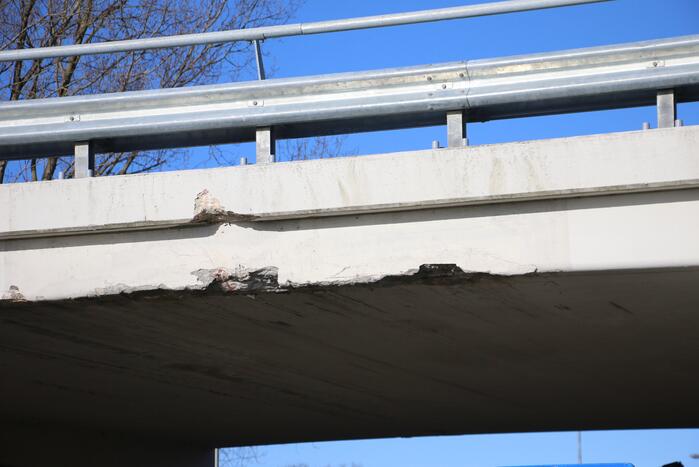 Vrachtwagen met kraan botst tegen viaduct