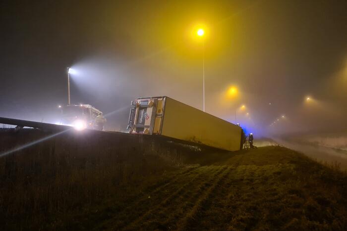 Vrachtwagen belandt op zijn kant in middenberm