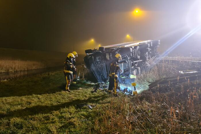 Vrachtwagen belandt op zijn kant in middenberm
