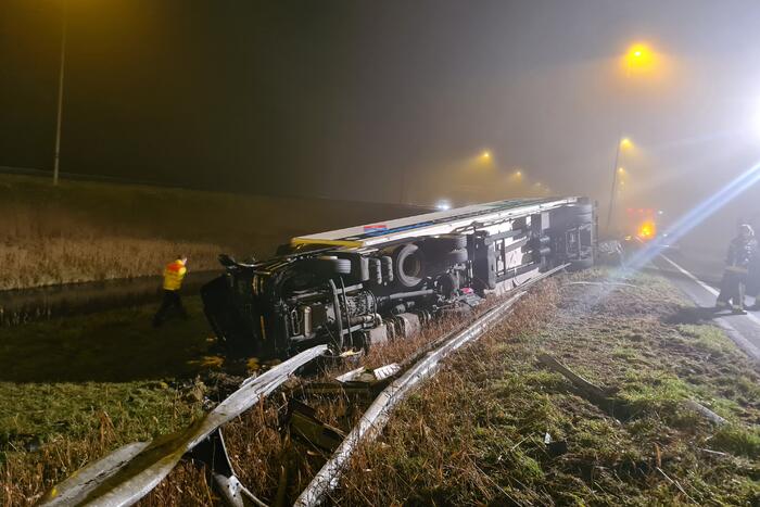 Vrachtwagen belandt op zijn kant in middenberm
