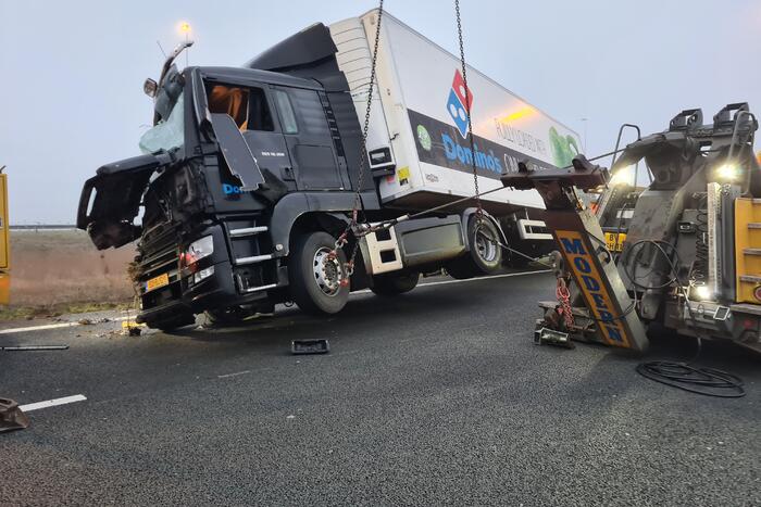 Vrachtwagen belandt op zijn kant in middenberm