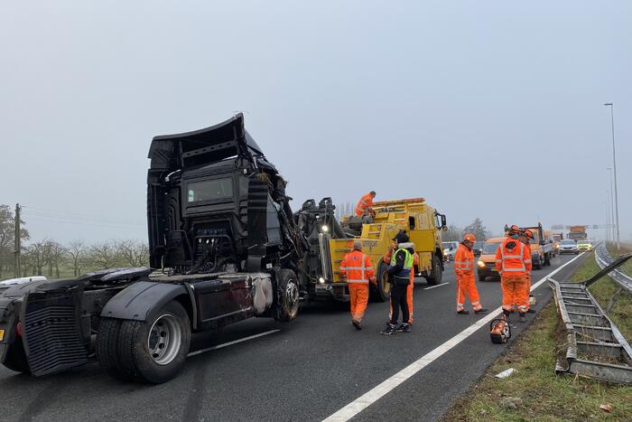 Vrachtwagen belandt op zijn kant in middenberm