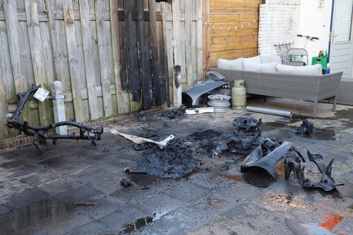 Scooter vat vlam, buren blussen met emmers water