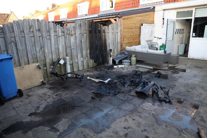 Scooter vat vlam, buren blussen met emmers water