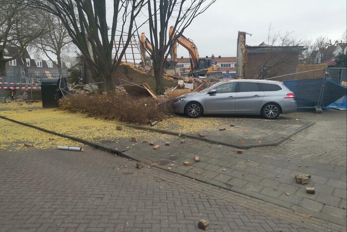 Muur valt op auto bij sloopwerkzaamheden