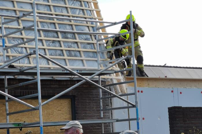 Brandweer blust brandende dakbedekking