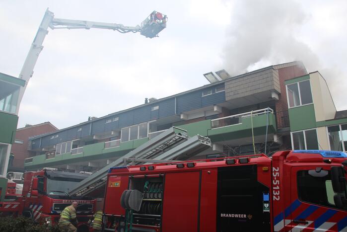 Brandweer blust brandend dak