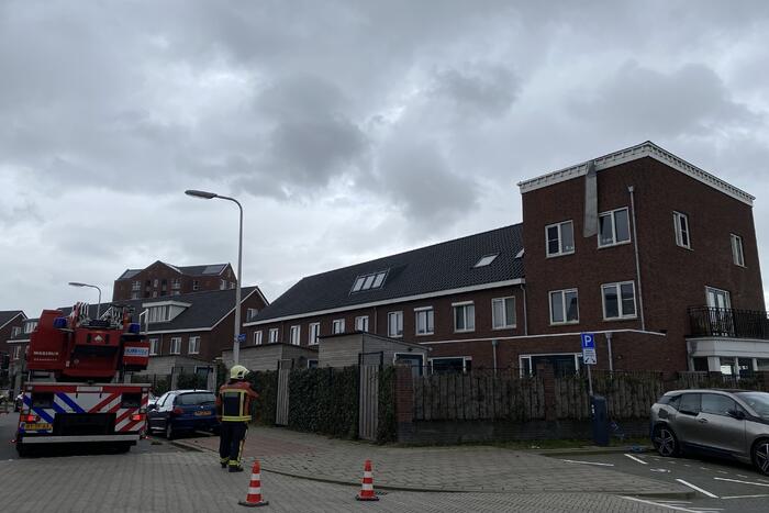 Brandweer haalt losgewaaide platen van dak