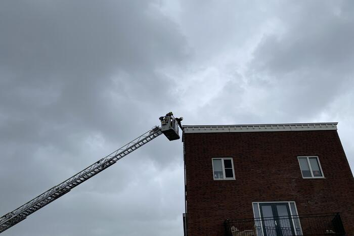 Brandweer haalt losgewaaide platen van dak
