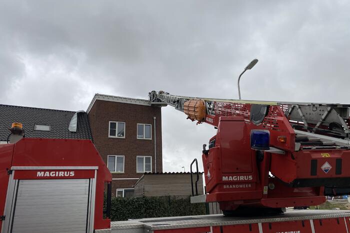 Brandweer haalt losgewaaide platen van dak