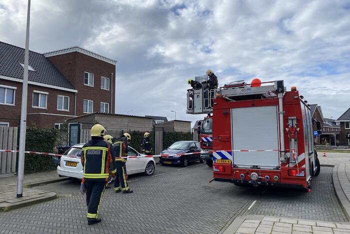 Brandweer haalt losgewaaide platen van dak