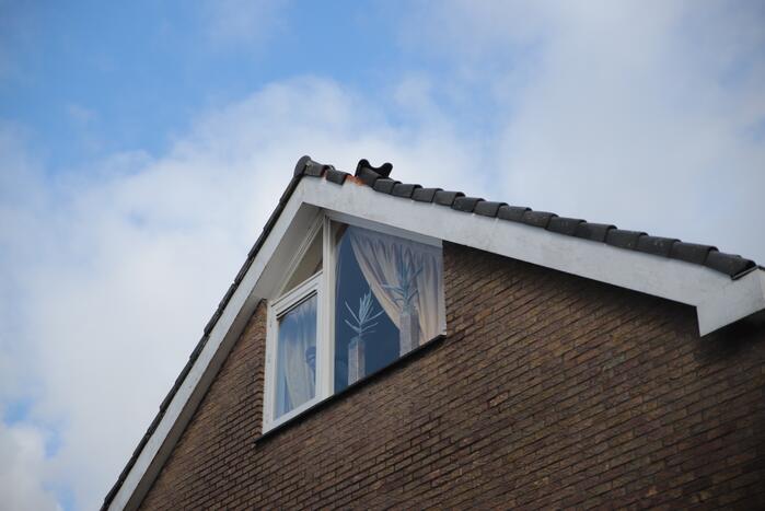 Brandweer zet losliggende dakpannen vast