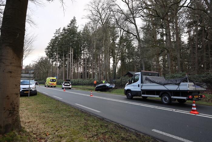 Auto eindigt aan overkant van de weg in hekwerk