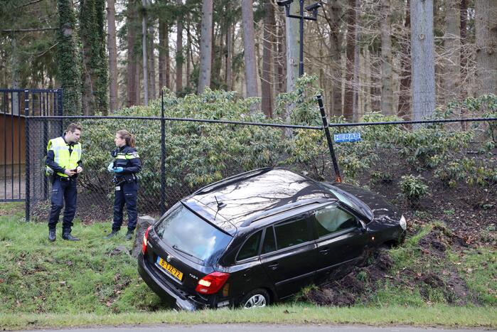 Auto eindigt aan overkant van de weg in hekwerk