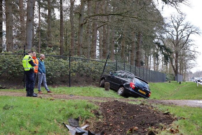Auto eindigt aan overkant van de weg in hekwerk