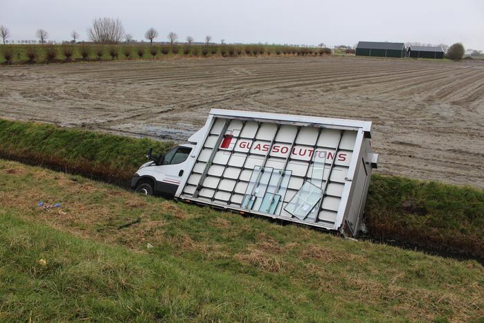 Bestelbus met glas belandt in sloot