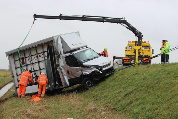 Bestelbus met glas belandt in sloot