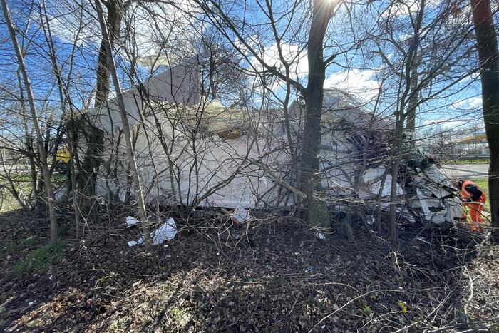 Vrachtwagen belandt in berm tegen boom