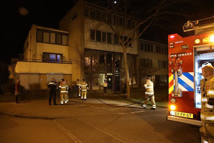 Brandweer blust brandende papiercontainer