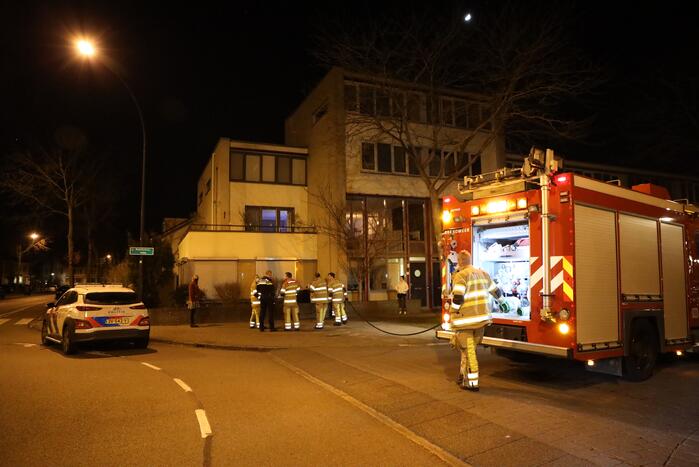 Brandweer blust brandende papiercontainer