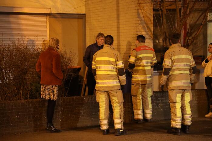 Brandweer blust brandende papiercontainer