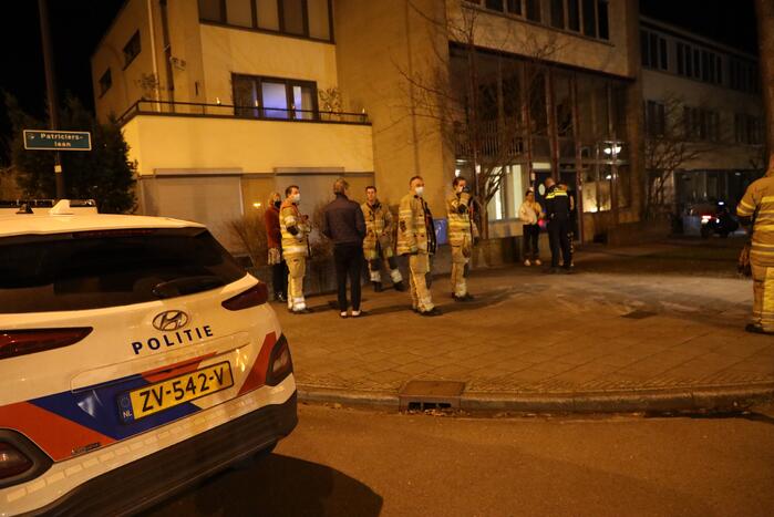 Brandweer blust brandende papiercontainer