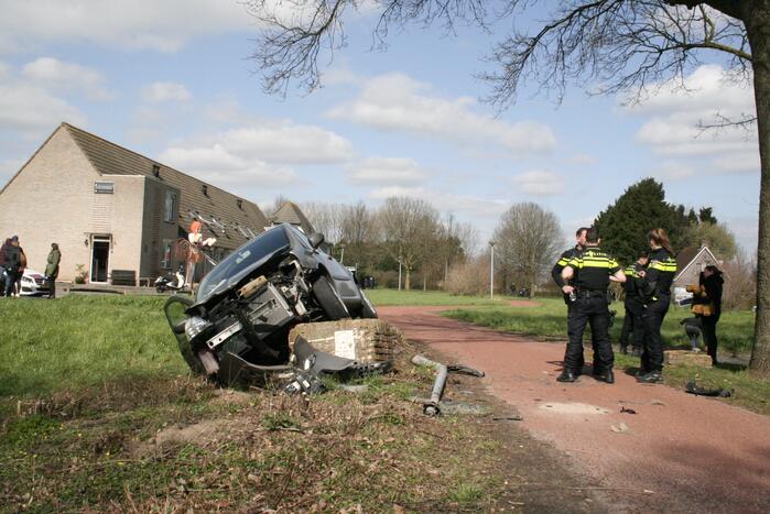 Auto botst op betonblok met lantaarnpaal