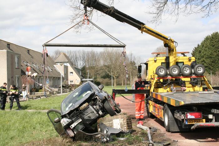 Auto botst op betonblok met lantaarnpaal