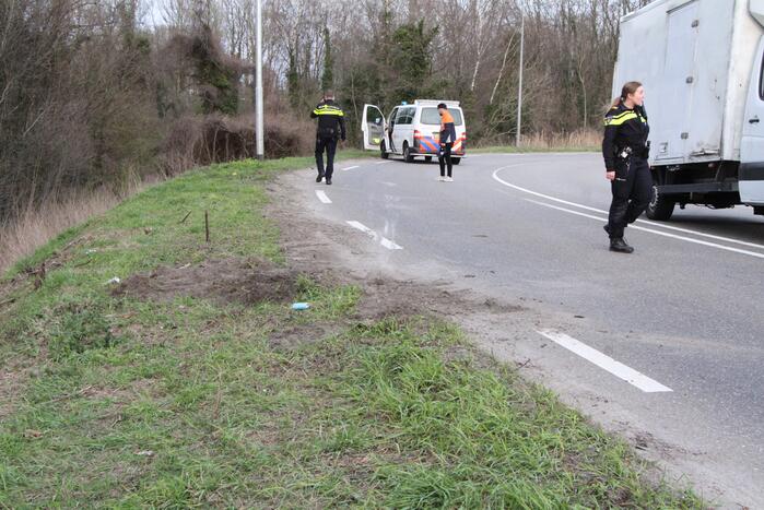 Bakwagen valt op zijkant in bocht
