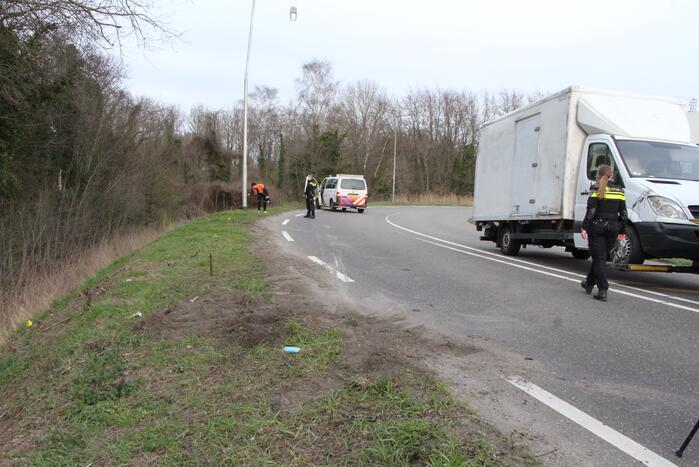 Bakwagen valt op zijkant in bocht
