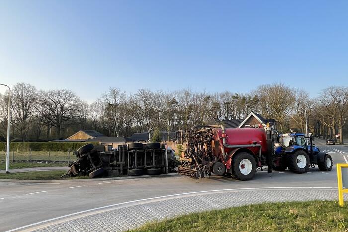 Giertank met mest gekanteld op rotonde