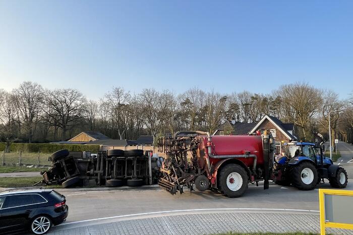 Giertank met mest gekanteld op rotonde