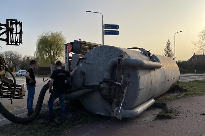 Giertank met mest gekanteld op rotonde