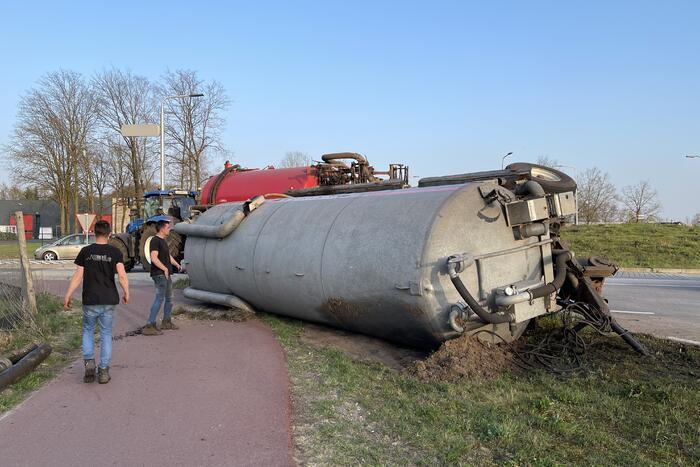 Giertank met mest gekanteld op rotonde