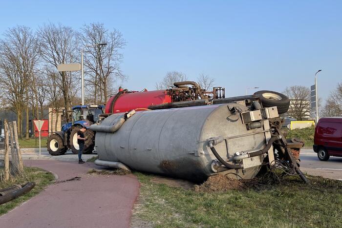 Giertank met mest gekanteld op rotonde