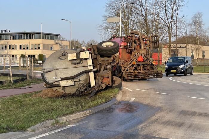 Giertank met mest gekanteld op rotonde