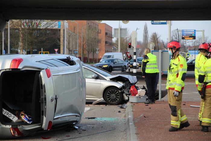 Auto op zijn kant bij verkeersongeval