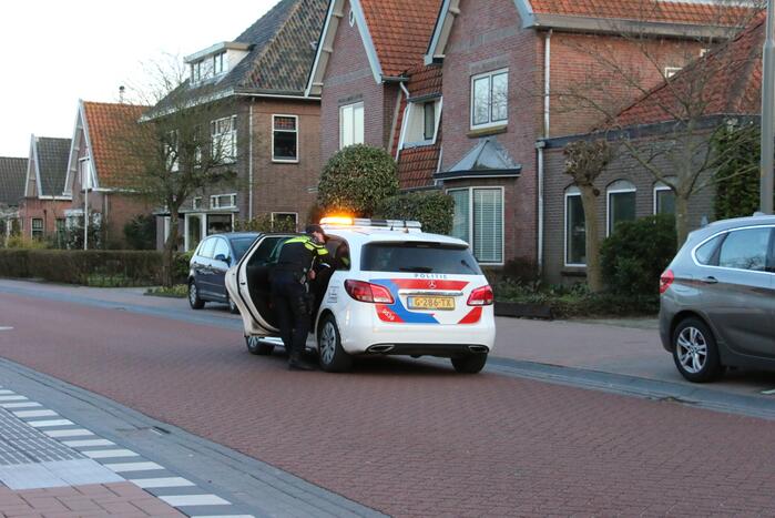 Busje op zijn kant na botsing met boom