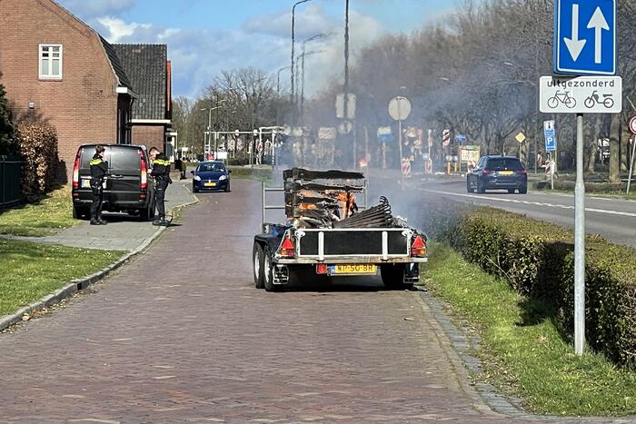Brandweer blust brandende aanhanger
