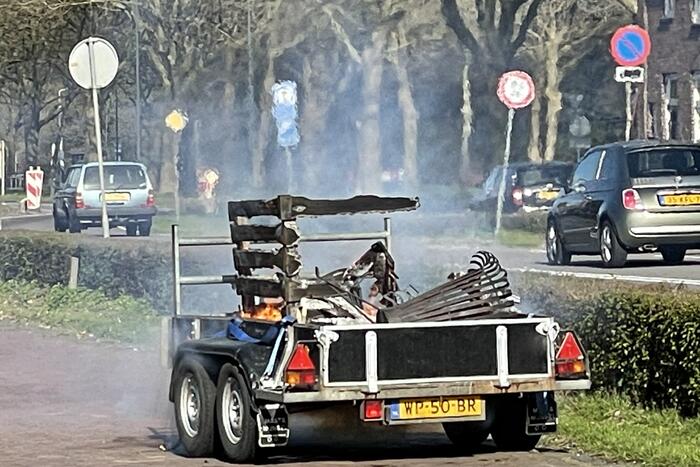 Brandweer blust brandende aanhanger