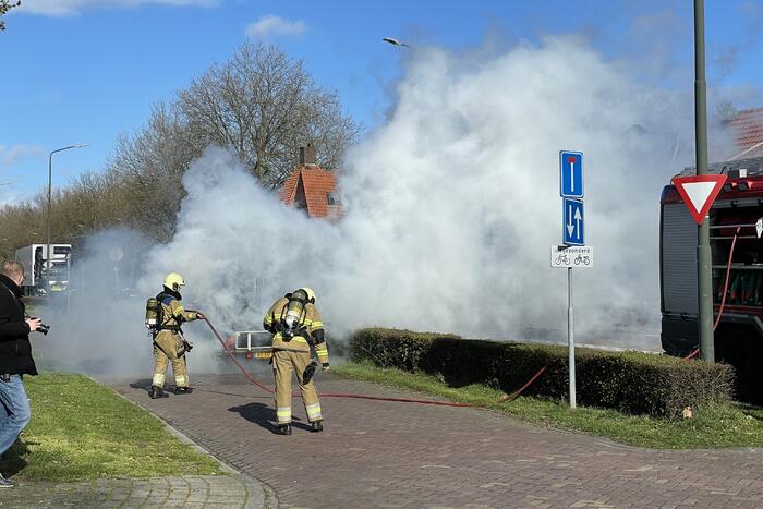Brandweer blust brandende aanhanger