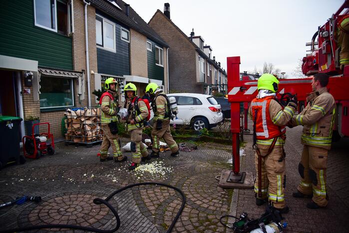 Brandweer blust stukken hout door brand in schoorsteen