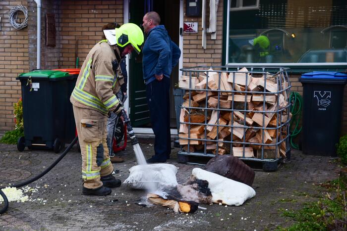 Brandweer blust stukken hout door brand in schoorsteen