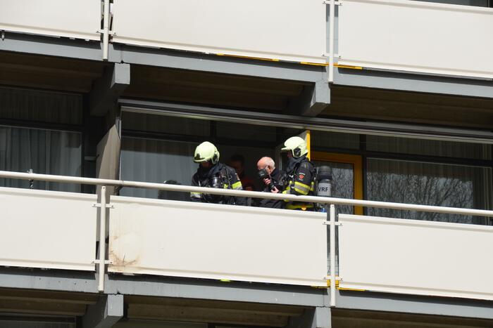 Brandweer blust brandende wasmand