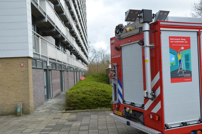 Brandweer blust brandende wasmand