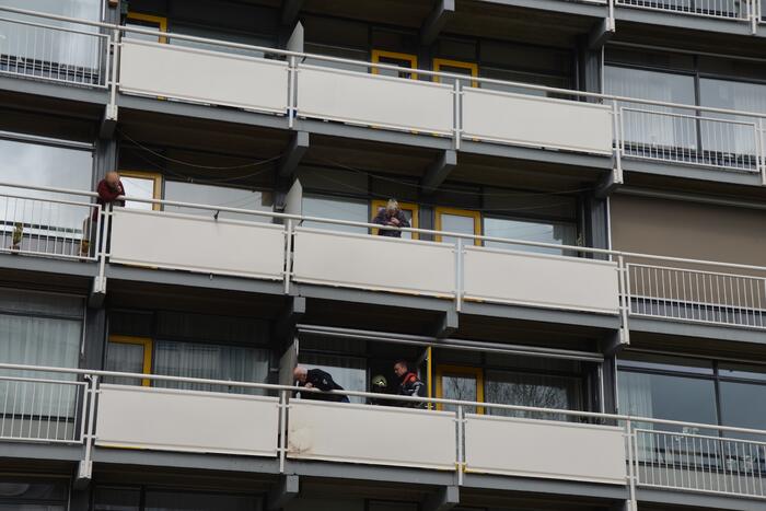 Brandweer blust brandende wasmand